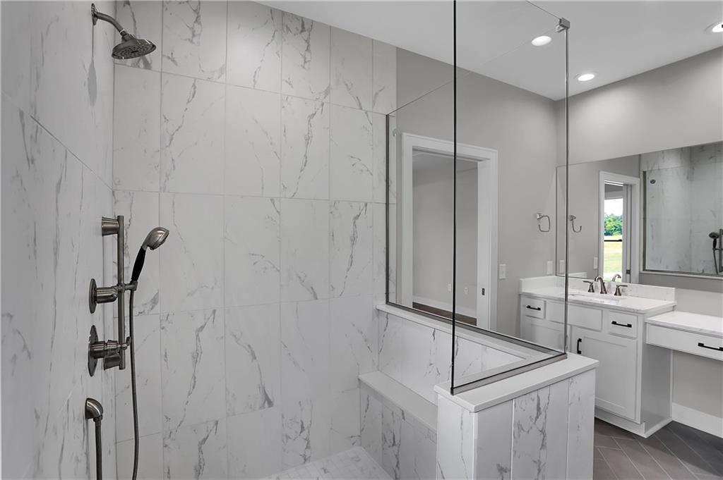 Marble walk in shower in tiled bathroom designed and created by Dave Sego Builders, Inc. in Greenfield, IN